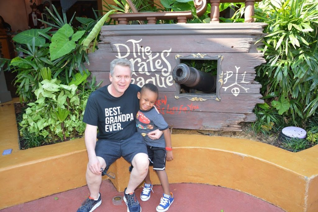 Grandpa and Grandkid in front of pirates of the Caribbean