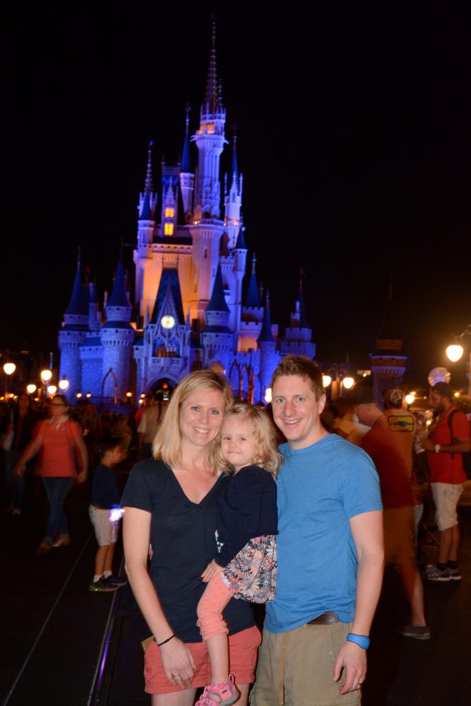Family in front of Cinderella Castle at night