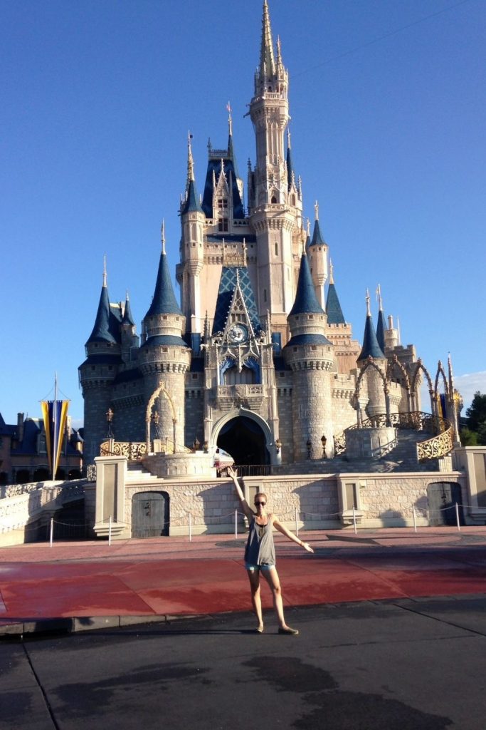woman standing in front of cinderella's castle in disney world