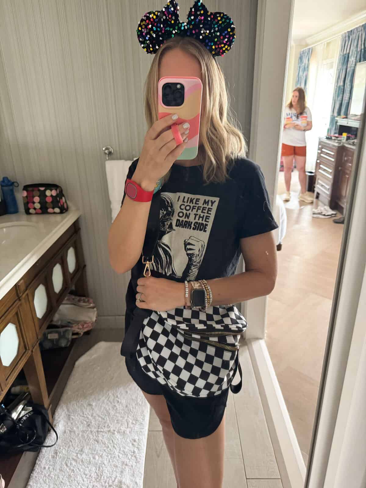 Woman with checkered bag and mickey ears.