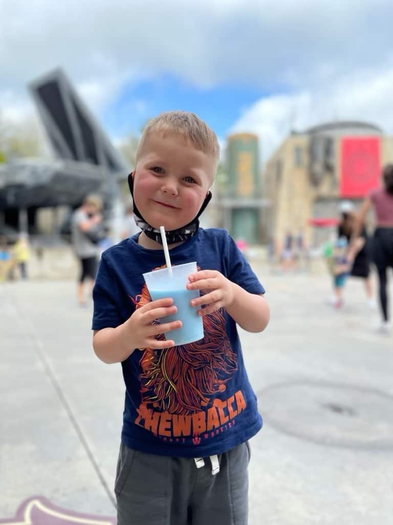 boy holding blue milk at disney world