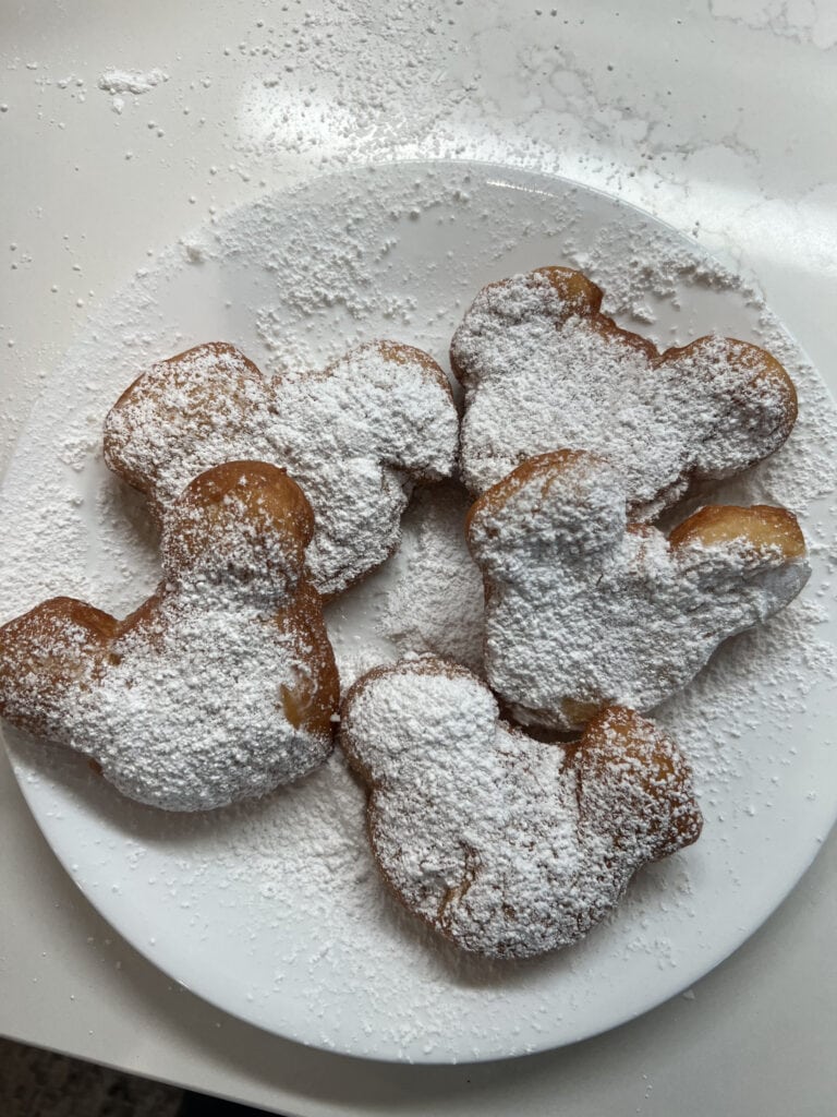 Mickey Mouse shaped beignets with powdered sugar