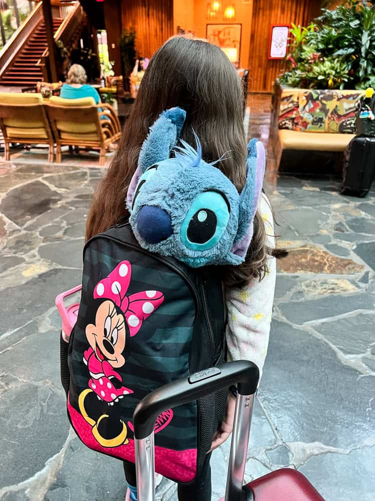 little girl with stuffed animal in backpack