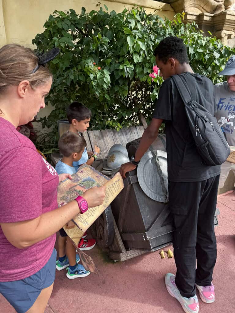 Woman and 3 kids doing the treasure hunt at Magic Kingdom.